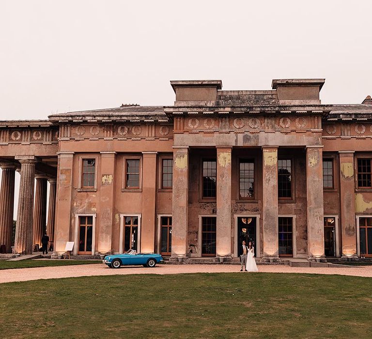 Mansion wedding at The Grange in Hampshire with blue vintage wedding car transport 