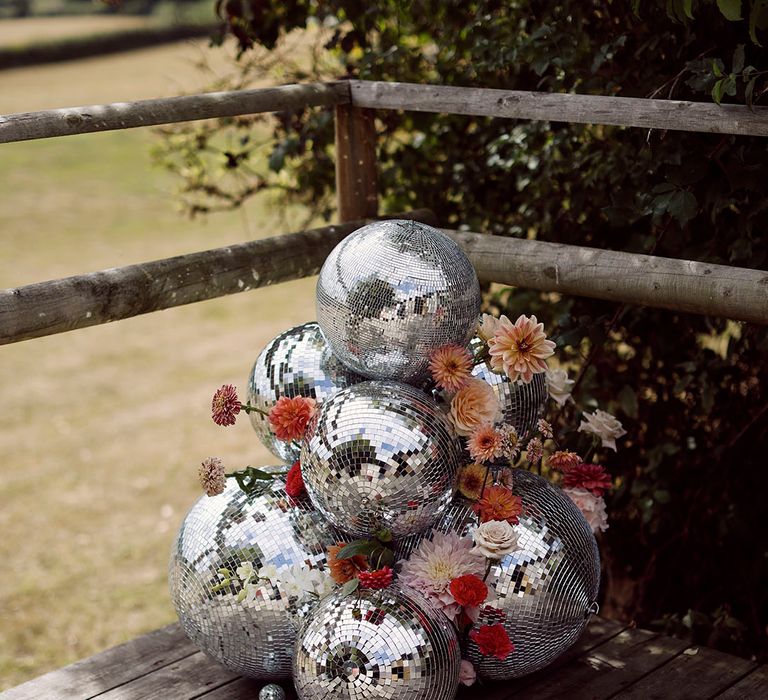 Disco balls layered on top of each other with pink flowers for decoration at Ibiza wedding 