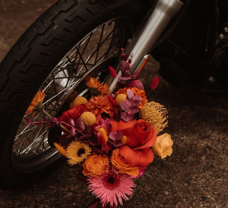 Pink red and orange vibrant wedding flowers new to wedding motorbike at German wedding editorial shoot with vinyl wedding arch