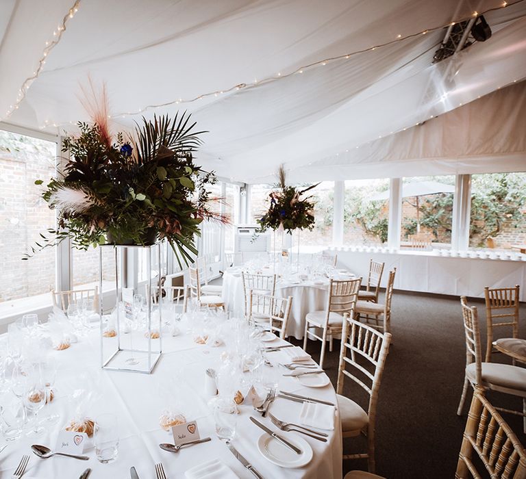 Round tables with tall table centrepiece wedding flowers at Essex wedding 