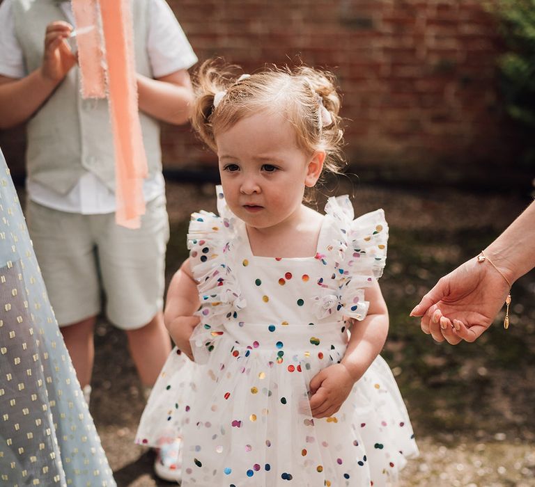 Flower girl wearing colourful ruffle flower girl dress