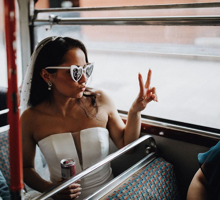 Bride wears sunglasses on the double decker bus on the way to the wedding breakfast 