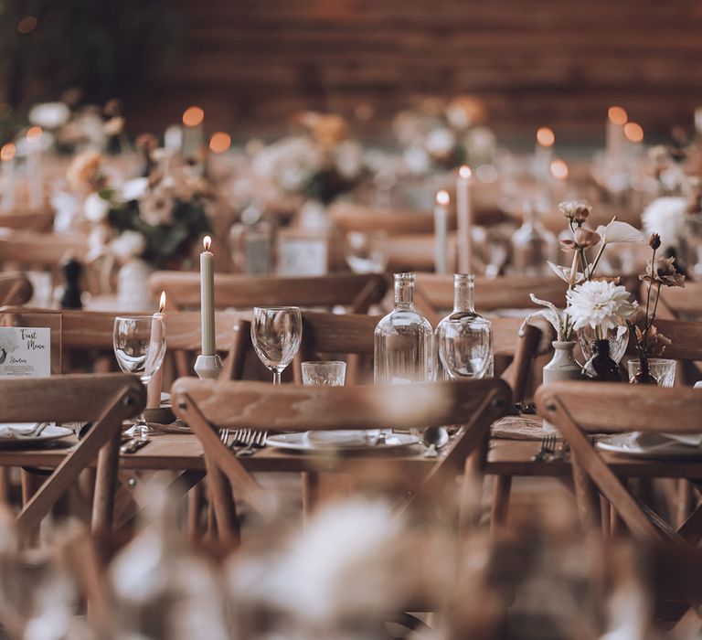 Minimalist wedding table setting on wooden tables with neutral flower bud vase arrangements for centrepieces 