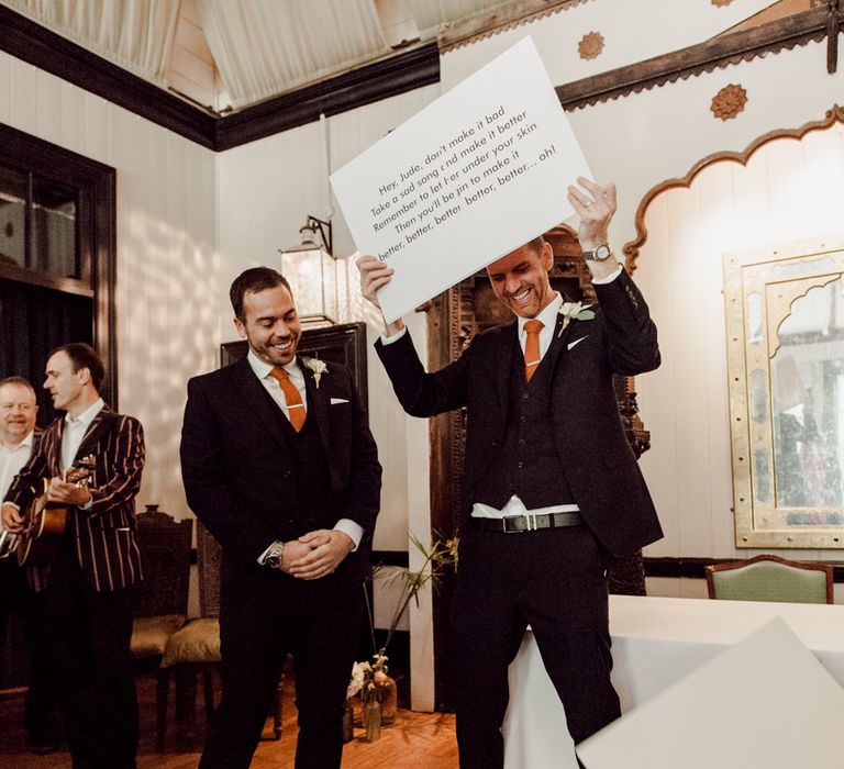 Groom holds up lyrics for guests to sing