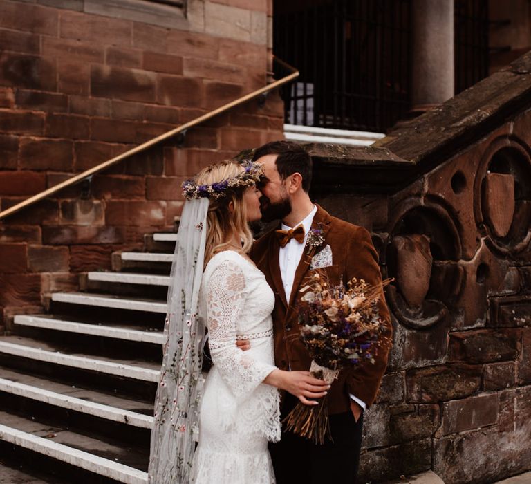 Bride and groom kissing outside Chester Town Hall 