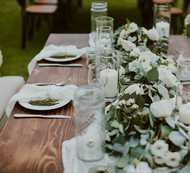 White flowers and candles line the outdoor tables