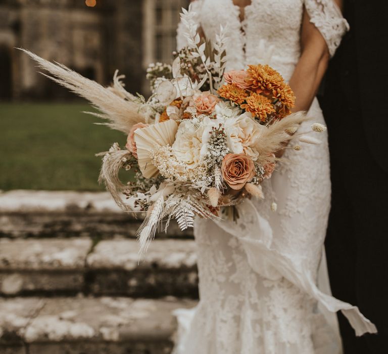 Dried and fresh flower wedding bouquet with neutral and peach flowers and grasses including dahlias, palm leaves, pampas and roses