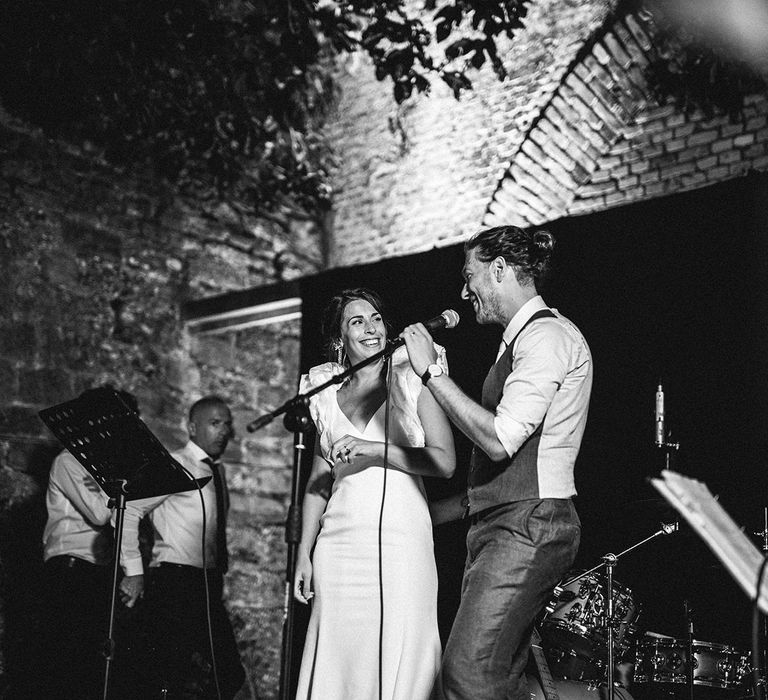 Bride and groom singing on stage