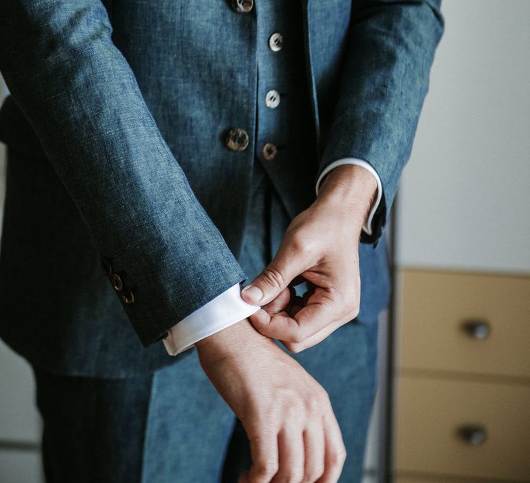 Groom in a navy blue three piece wedding suit on the wedding morning 