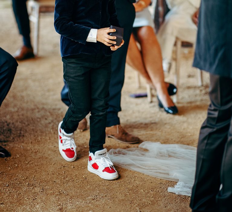 Pageboy in deep blue suit and trainers