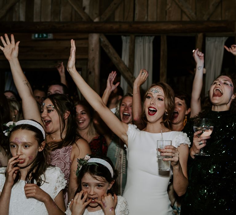 Wedding guests enjoying the evening band with glitter paint and jewels on their faces. 