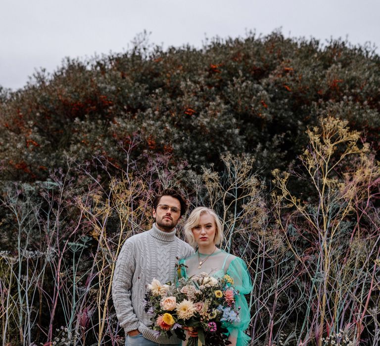 Cool bride and groom portrait on the beach at their intimate elopement with the bride in a sheer pastel wedding dress 