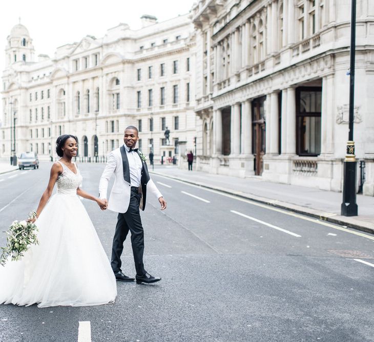 Groom leads bride across the street in London