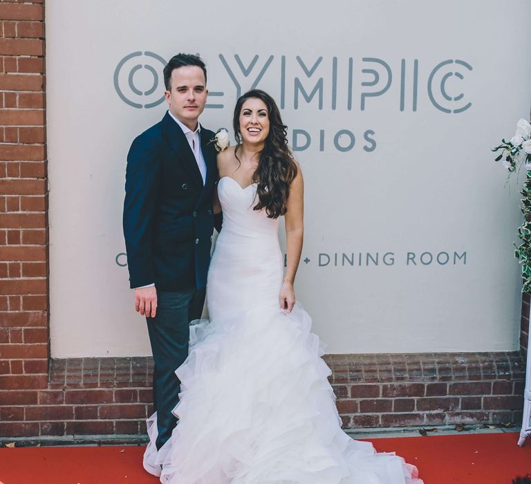 Bride and groom on the red carpet outside Olympic studios in Barnes