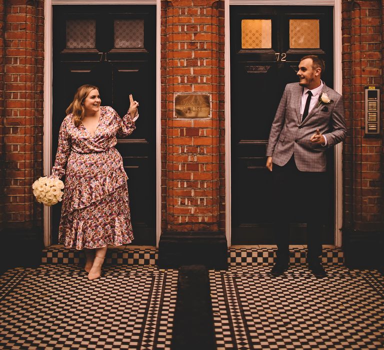 Bride & groom stand in doorways as they look across at one another