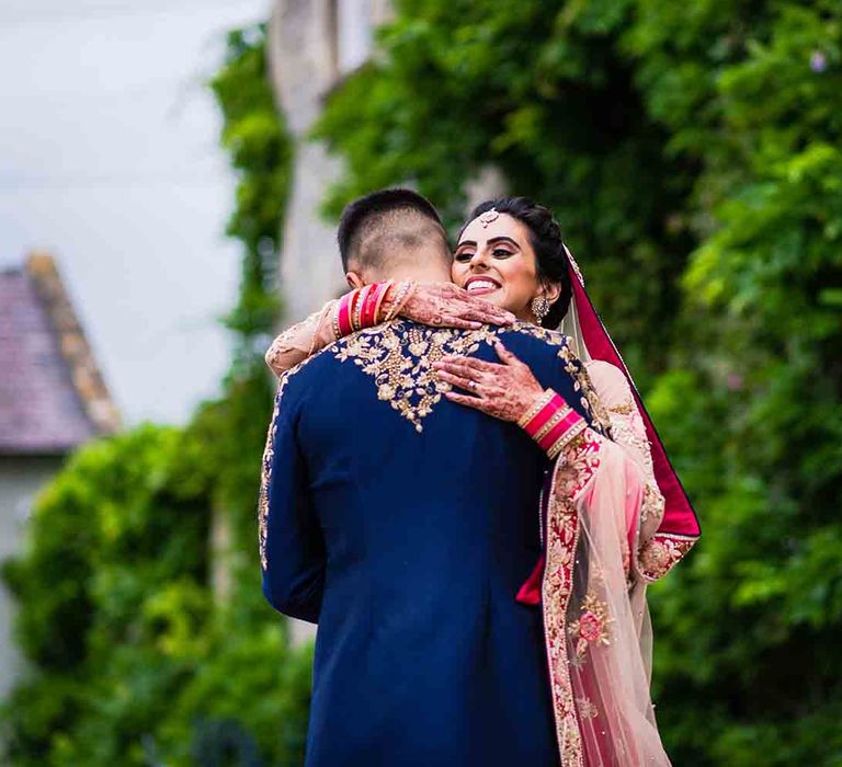 Bride with henna embraces groom 