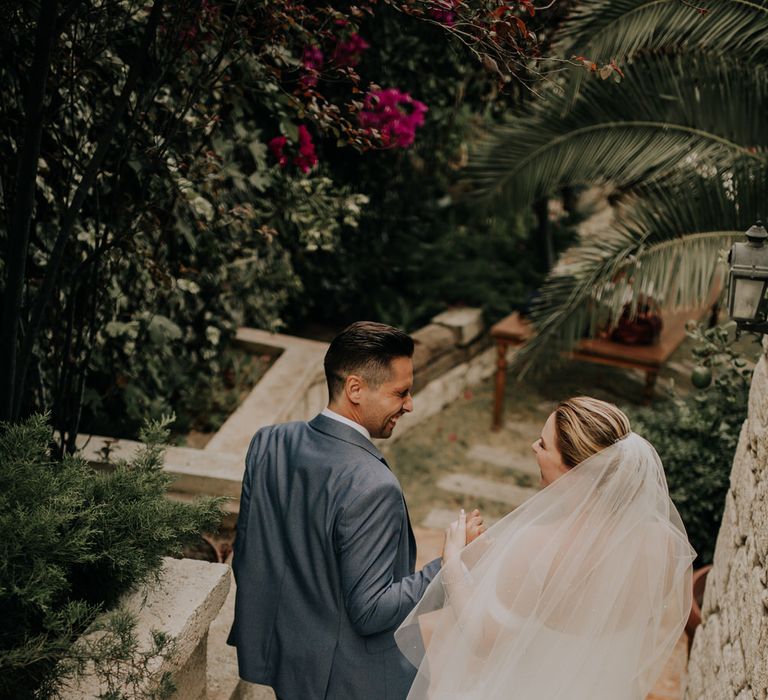 Bride and groom walking down the stairs hand in hand at their outdoor Turkish wedding venue