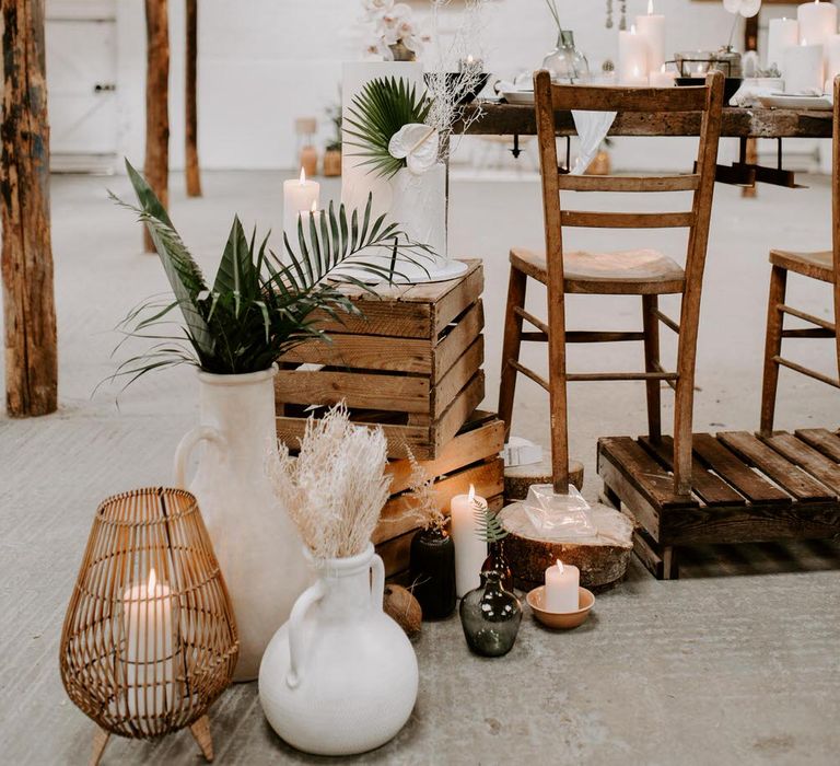 Tropical wedding set up with neutral flowers, tropical plants, wooden bar stools and crates