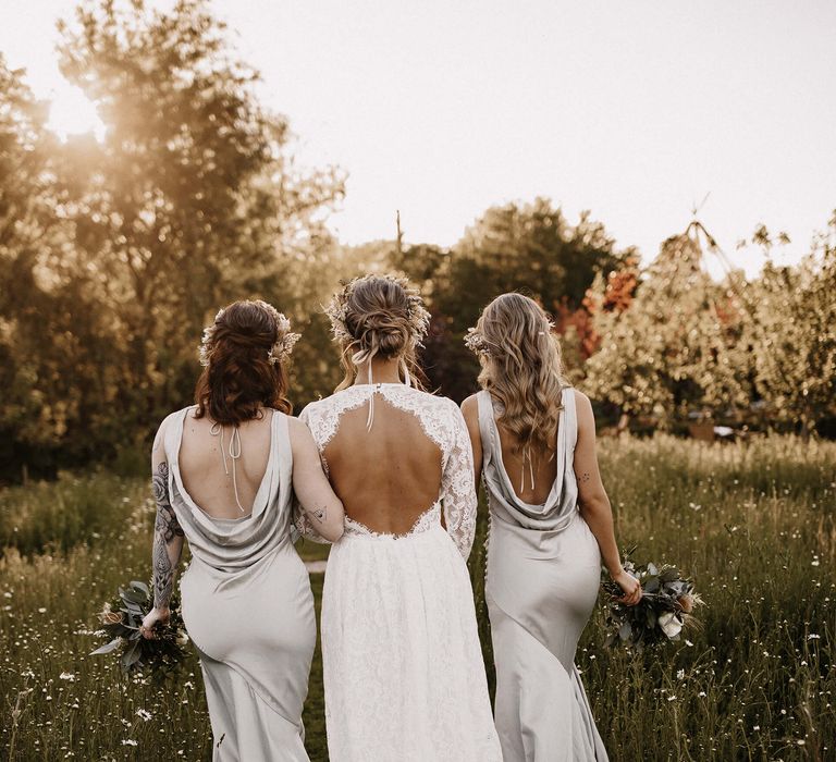 Bride and bridesmaid wedding hairstyles with long wavy hair, half up half down with braid, and a loosely pinned bridal bun