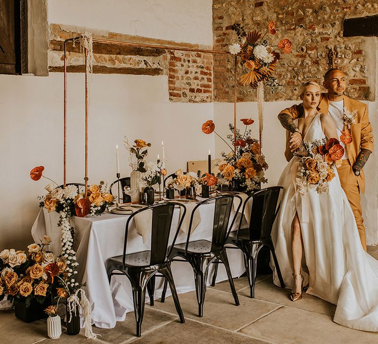 Cursdahll Barn contemporary wedding inspiration with retro signs, industrial chairs, cooper frames, yellow and orange flowers and a mustard suit 