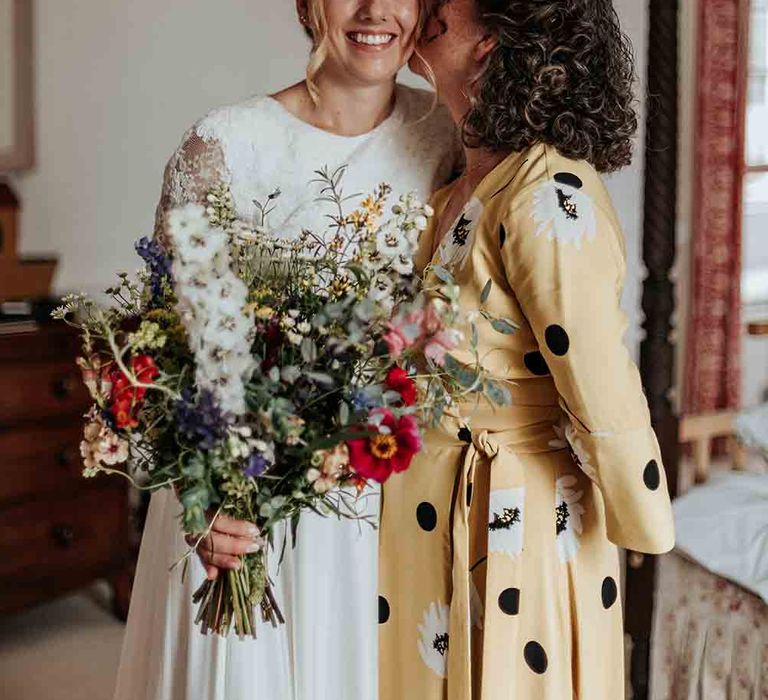 Bride clutches wildflower bouquet during preparations at Cadhay House