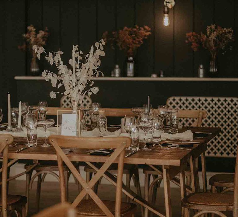 Wooden tables at wedding with dried flower arrangement centrepieces