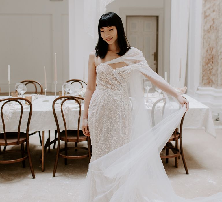 Stunning South Asian bride with a blunt fringe and shoulder length hair in a strapless wedding dress with chiffon scarf 