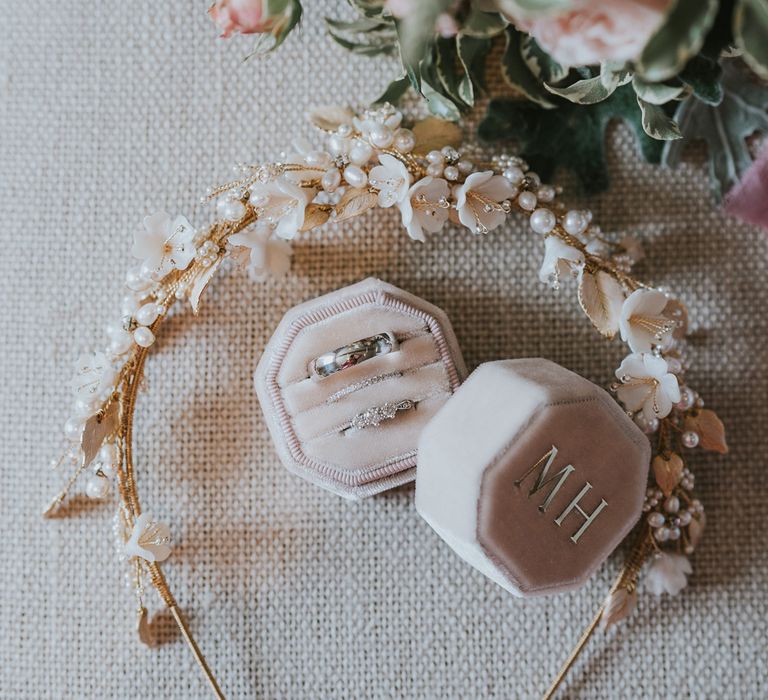 Bridal headband with pearls, gold wiring and white florals next to pink velvet octagonal ring box with silver printed initials next to white and pink florals for summer wedding at Primrose Hill Farm