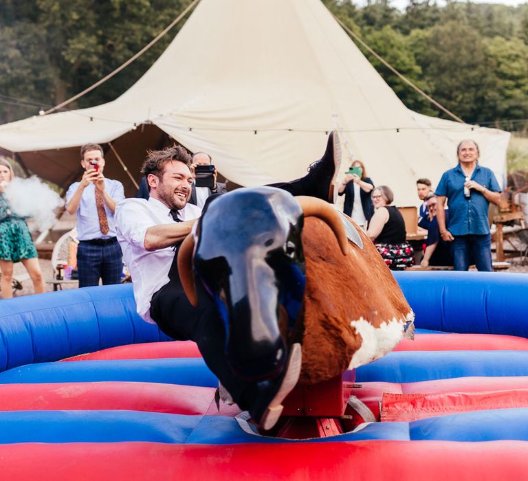 Groom in white shirt and black trousers falls off bucking bronco at The Bridal Barn in Claverley after outdoor summer wedding ceremony