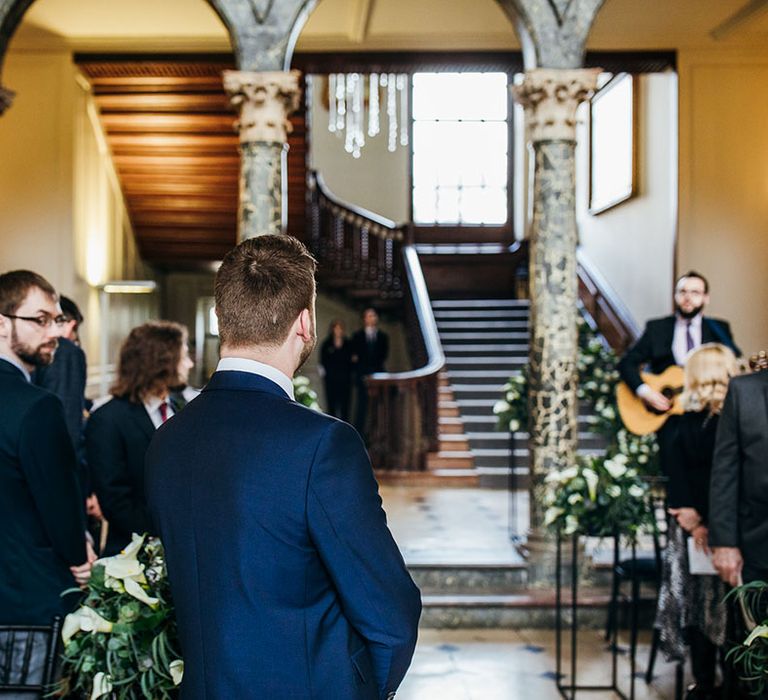 Groom awaits his bride during wedding ceremony