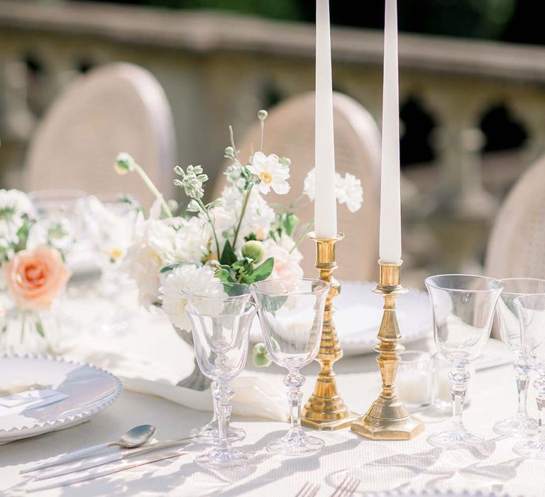 Candlesticks in golden candlestick holder on simple tablescape for outdoor reception