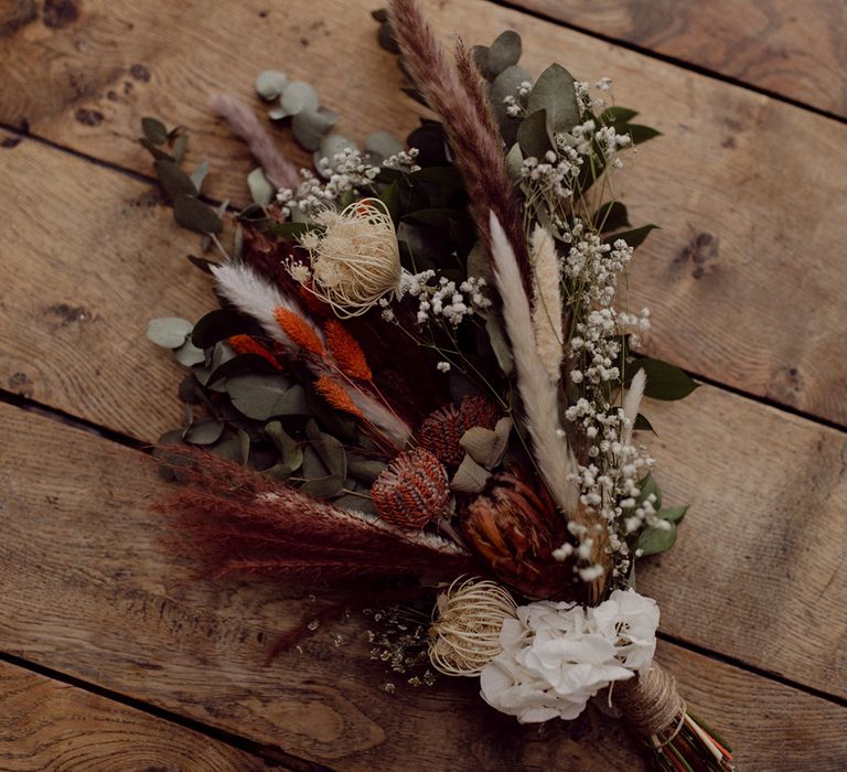 Autumnal coloured dried flower wedding bouquet with oranges, whites and greens