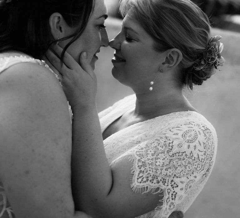 Brides lean in for a kiss at their destination outdoor wedding in Barcelona, Spain 