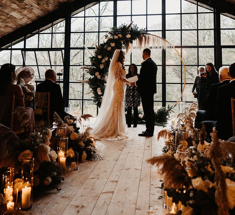 Candle lanterns and dried flower aisle decoration with moongate flower decoration at the altar for Hidden River Barn wedding