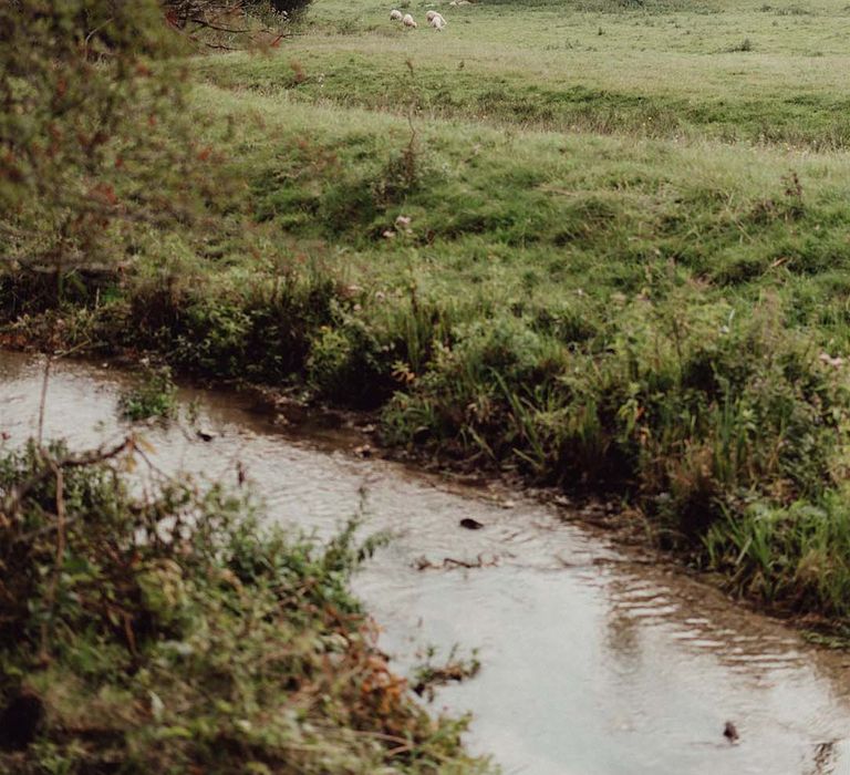 Wedding venue setting of countryside with sheep and river 