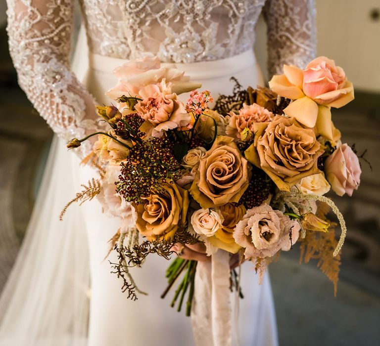 Pink and toffee garden roses in wedding bouquet for autumnal wedding in country house