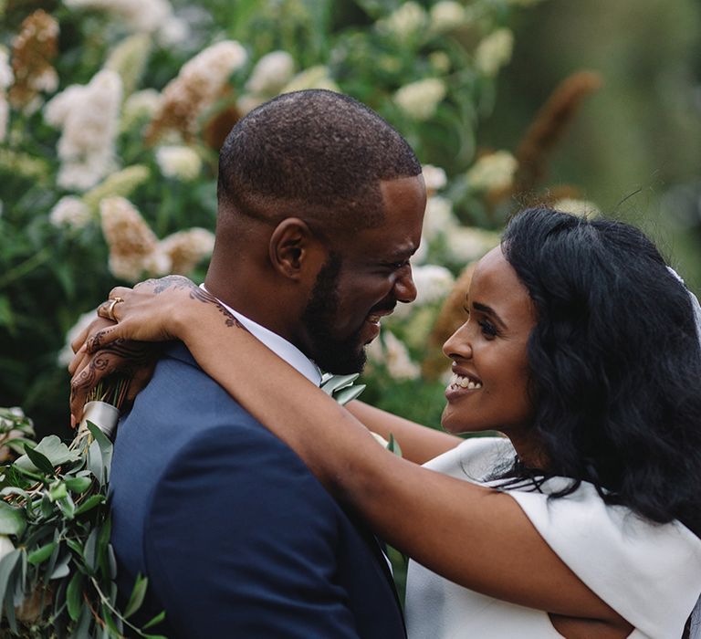 Bride and groom hug and look into each other's eyes