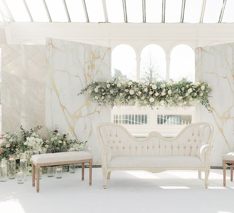 Isla Gladstone Conservatory finished with fresh white floral bouquets and green foliage and white furniture in front of large bay window