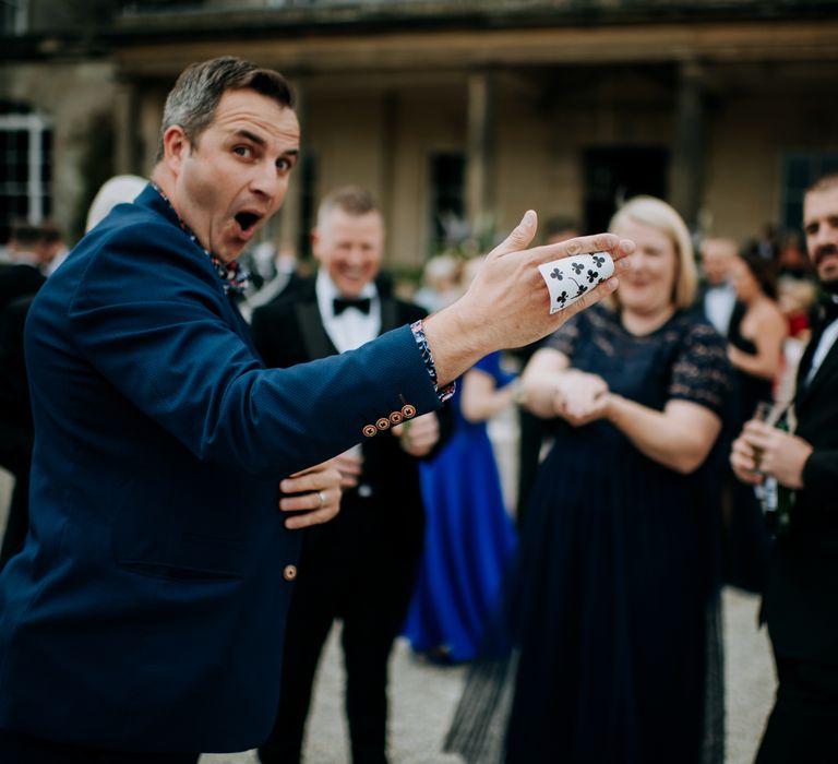 Magician does card trick outdoors after wedding ceremony at Birdsall House