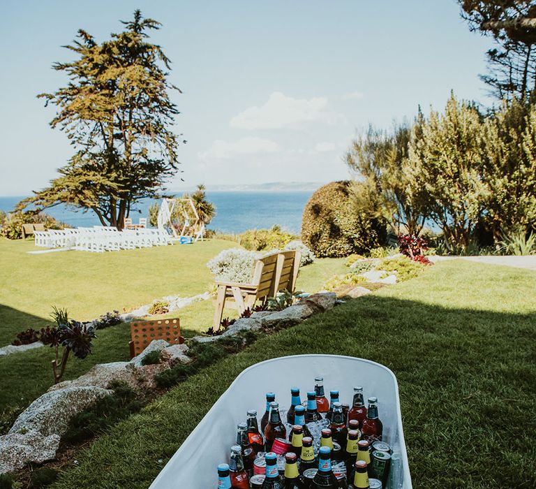 Bath filled with alcohol outdoors on wedding day in Cornwall 