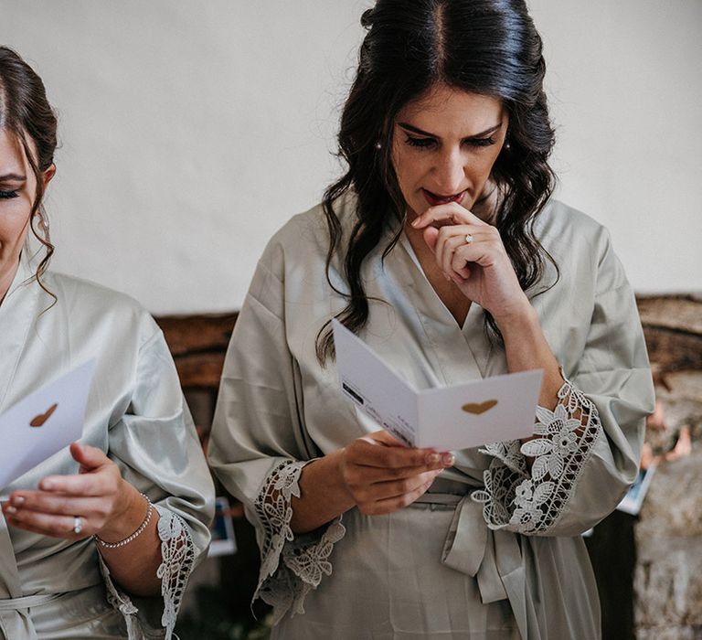 Bridesmaids in sage green satin robes get emotional as they read personal letter on the morning of the wedding 