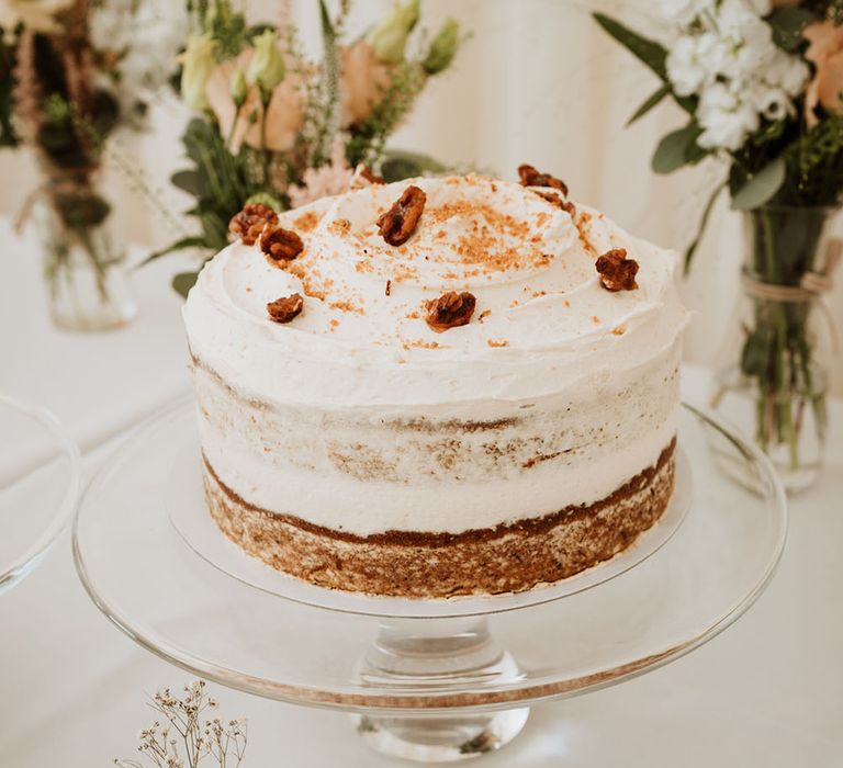 Naked carrot cake with white frosting and walnut decor 