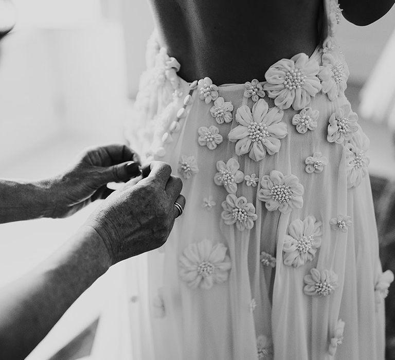 Details on the bride's Emma Beaumont wedding dress with flowers and tiny pearls 