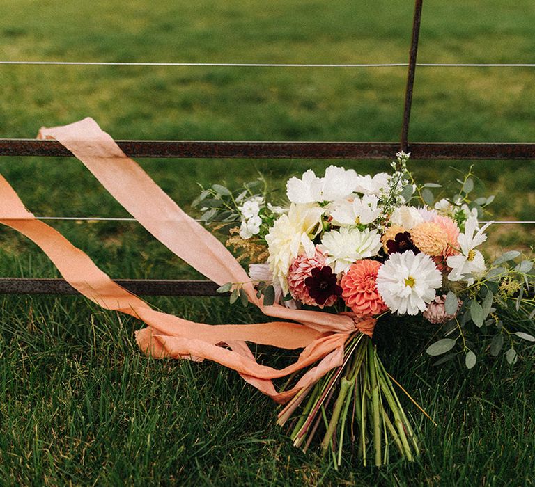 Homegrown DIY wedding flower bouquet with cosmos and dahlias tied with an orange ribbon 