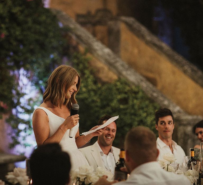 Bride gives speech during outdoor wedding reception in Tuscany