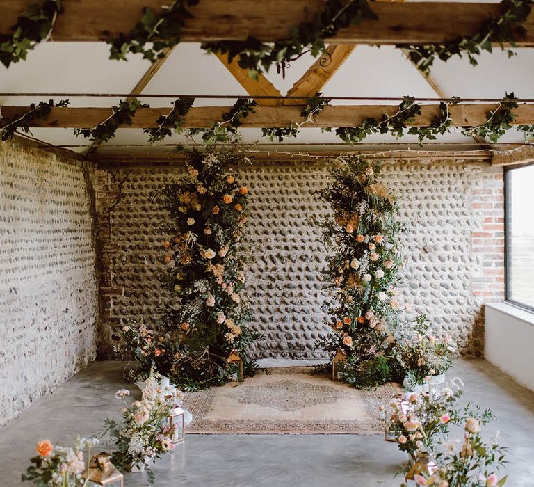 Wedding column flower arrangements decorate the altar with small arrangements of flowers with metal lanterns for industrial style wedding 