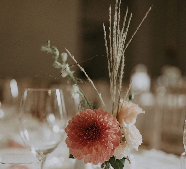 Pink dahlia and white roses in bud vases decorate the wedding tablescape 