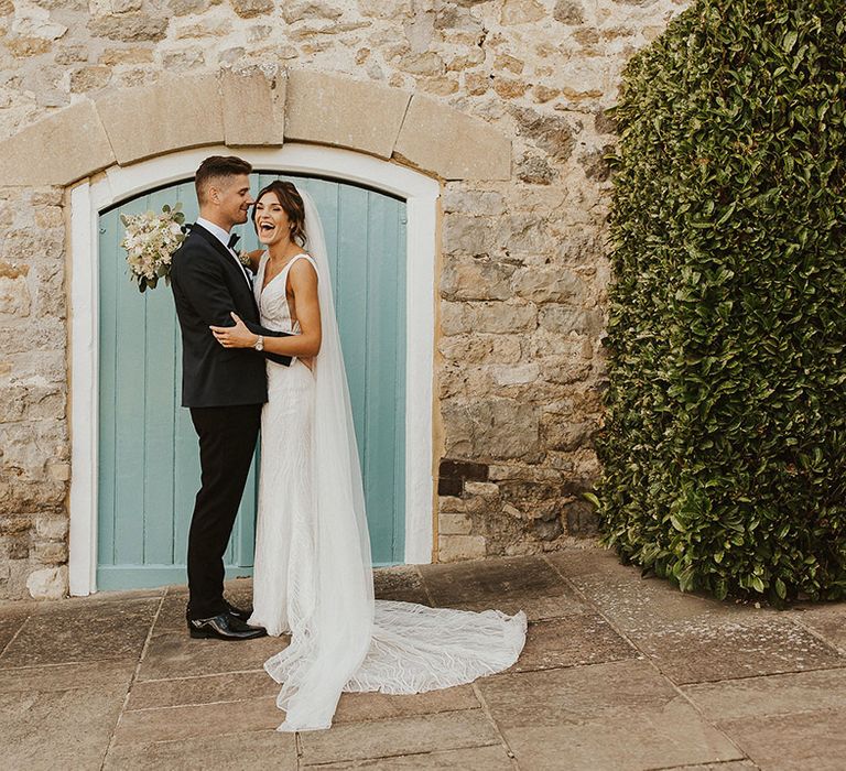 The bride and groom pose together for barn wedding at Priston Mill, Bath 