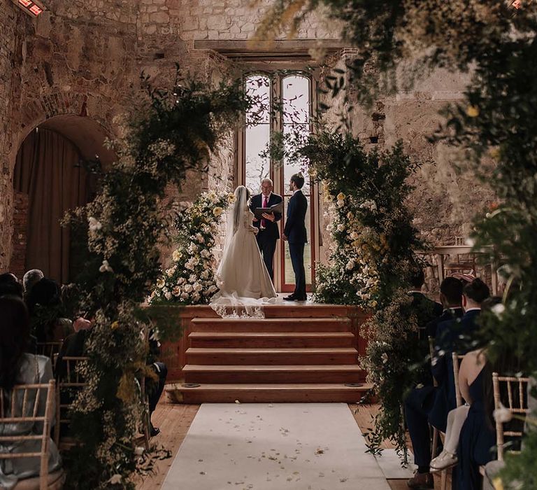 Lulworth Castle wedding venue in Dorset with botanical floral arrangements and columns decorating the venue 