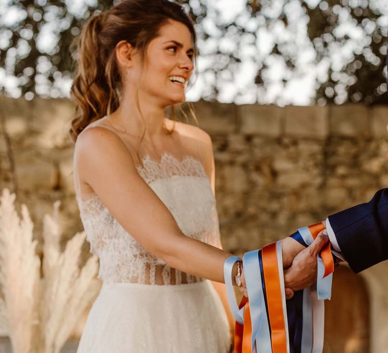 boho bride in a strapless lace wedding dress at handfasting ceremony